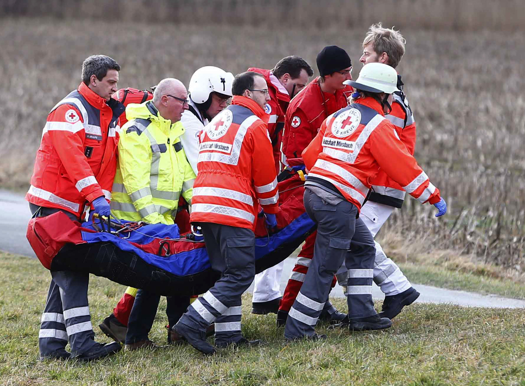 Происшествия: Rescue personnel carry an injured person near the site where two trains collided head-on near Bad Aibling, southern Germany, Tuesday, Feb. 9, 2016. Several people have been killed and dozens were injured. (AP Photo/Matthias Schrader)