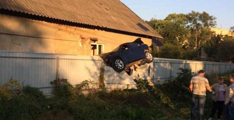 В Черновцах полицейский на BMW повис на заборе дома