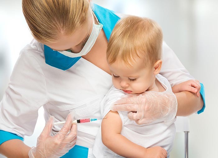 врач делает прививку маленькому ребенку