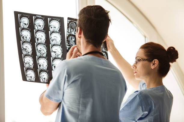 врачи смотрят на снимок человеческой головы