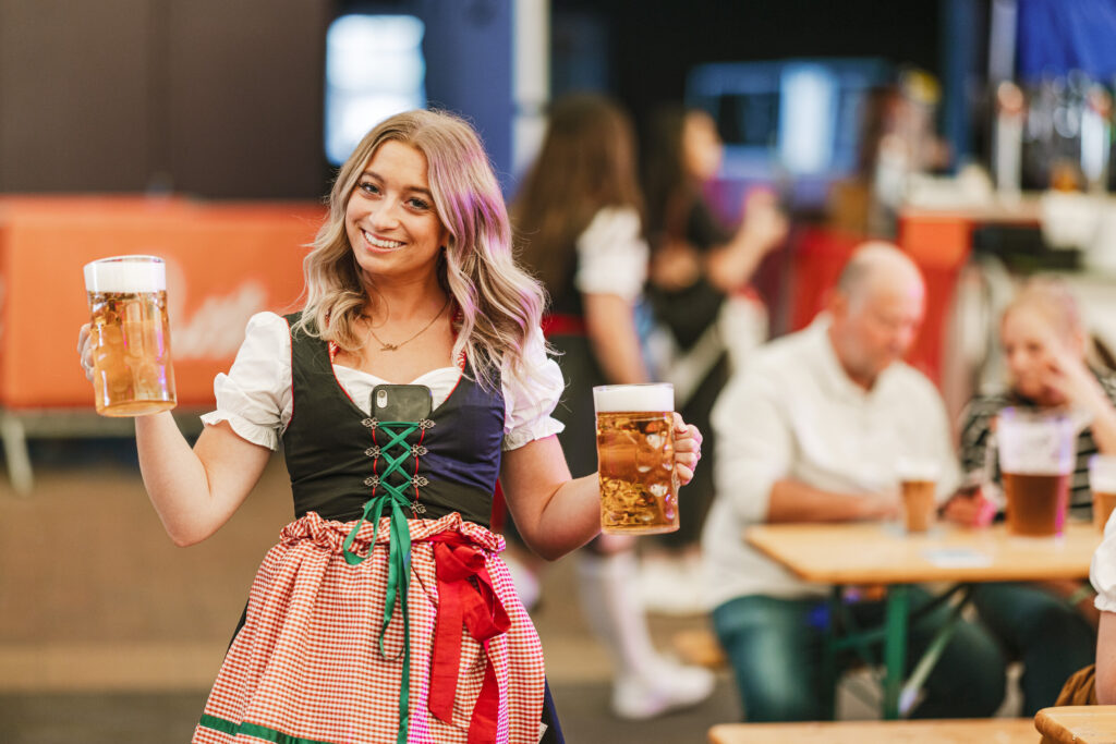 девушка-официантка с двумя бокалами пива